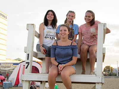 smiling girls sitting on lifegaurd stand