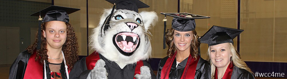 Three WCC graduates with Vic the Wildcat mascot